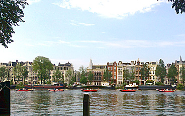 Red boats rowing on the Amstel in Amsterdam